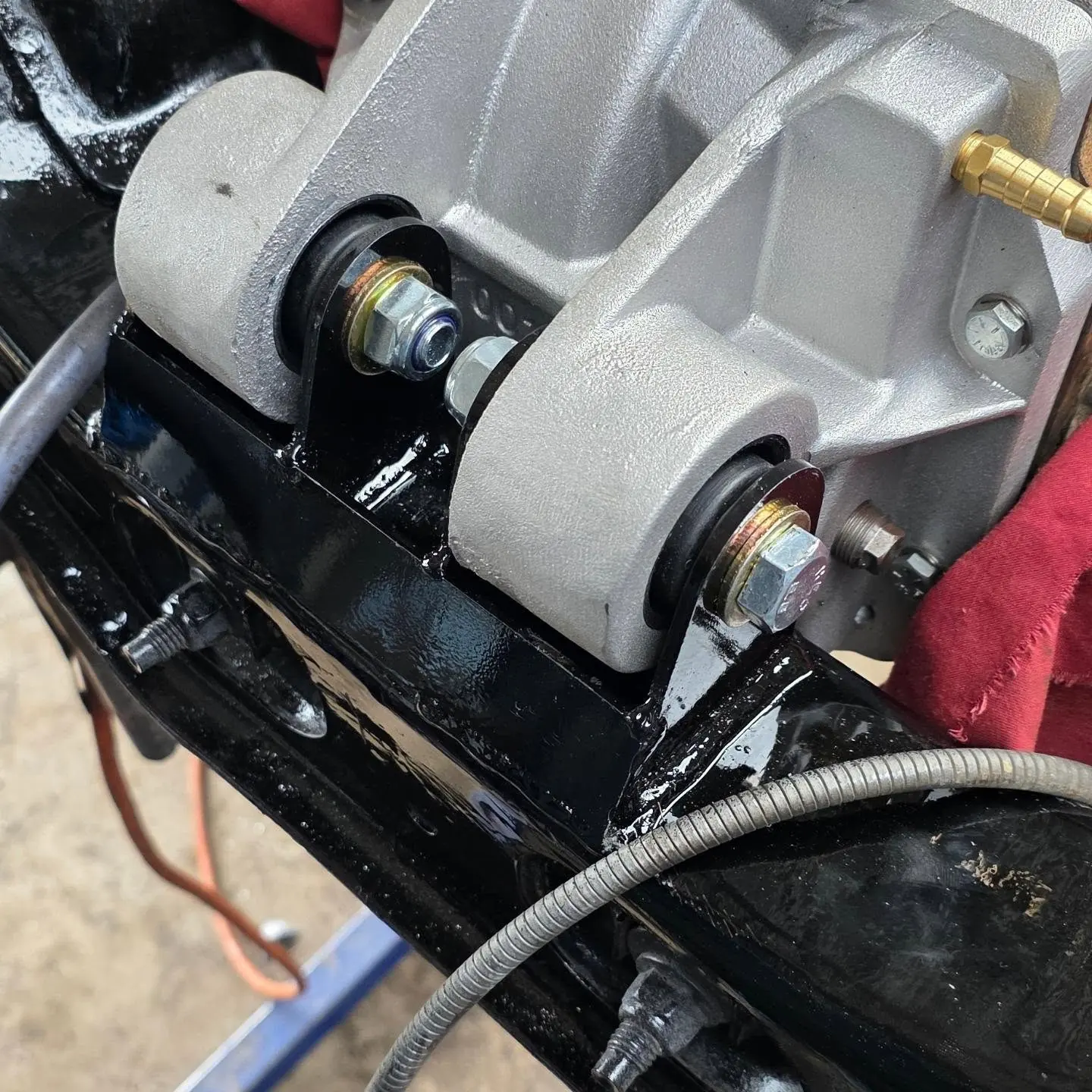 Close-up of a painted cradle with diff bush, bolt and washer on the new bracket